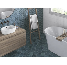 Badkamer met wastafel, bad, handdoekladder en wand- en vloertegels