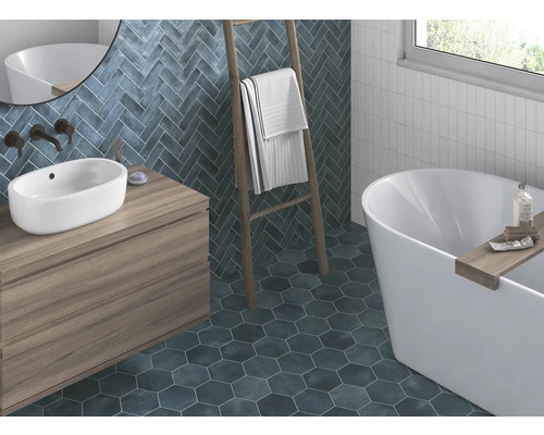 Badkamer met wastafel, bad, handdoekladder en wand- en vloertegels