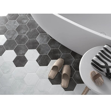 Badkamer met zeshoekige vloertegels, bad, handdoek en slippers