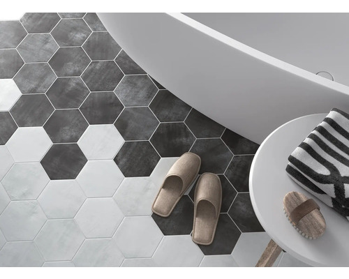 Badkamer met zeshoekige vloertegels, bad, handdoek en slippers