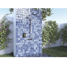 Buitendouche met betegelde wand in een tuinomgeving