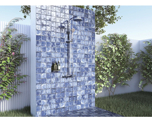 Buitendouche met betegelde wand in een tuinomgeving