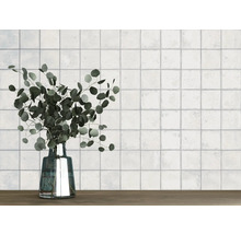 Wand met vierkante tegels en een vaas met eucalyptus op een houten tafel