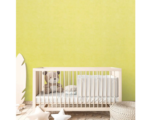 Babykamer met ledikant, teddybeer en decoratieve elementen voor een lichtgele muur