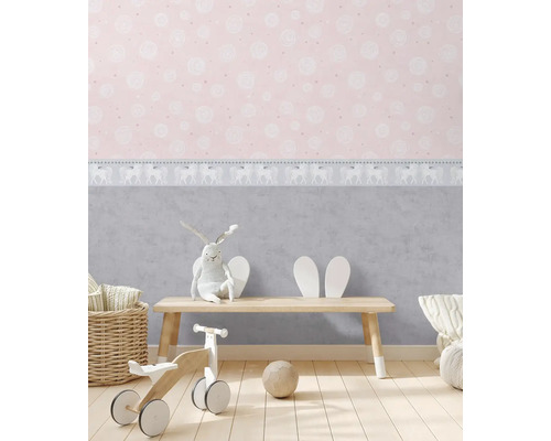 Kinderkamer met roze behang, speelgoed en een klein houten bankje.