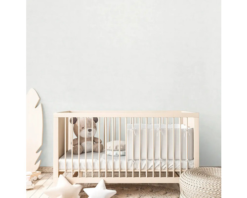 Een kinderkamer met een babybedje, een teddybeer en decoraties.