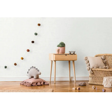 Kinderkamer met houten commode, rotan stoel en decoratie artikelen