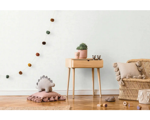 Kinderkamer met houten commode, rotan stoel en decoratie artikelen