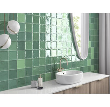 Badkamer met groene tegels, wastafel en spiegel
