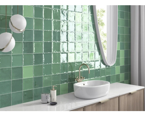 Badkamer met groene tegels, wastafel en spiegel