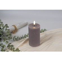 Decoratieve ledkaars naast boekrol en eucalyptus takken