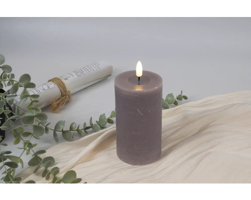 Decoratieve ledkaars naast boekrol en eucalyptus takken