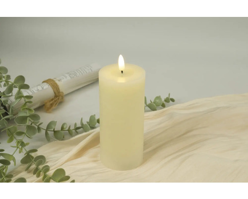 Decoratieve LED-kaars op beige stof met eucalyptus en papierrol