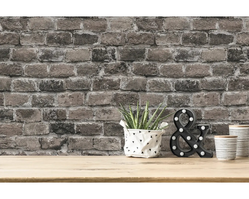 Muur met bakstenenbehang, plant, decoratief object en bekers op een tafel