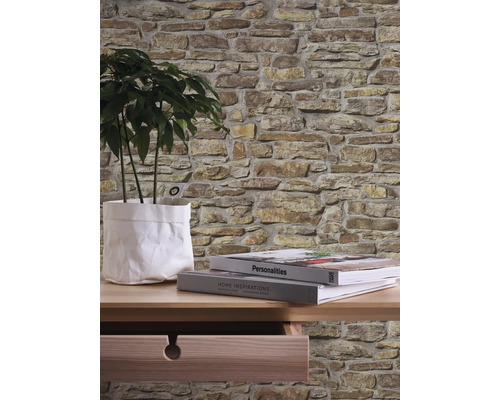 Wanddecoratie met steenlook behang, tafel, kamerplant en boeken.