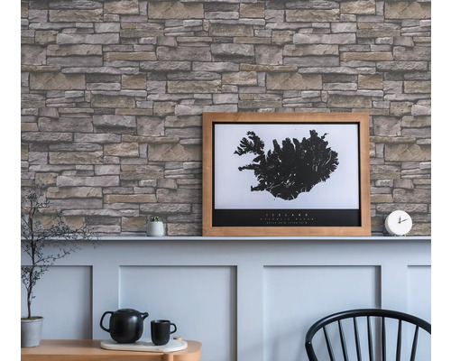 Woonkamer met een muur met steenlook behang en een ingelijste IJsland poster