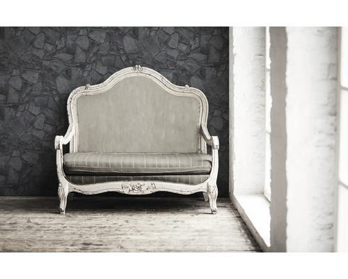 Antieke sofa met houten frame en bekleding voor een stenen muur