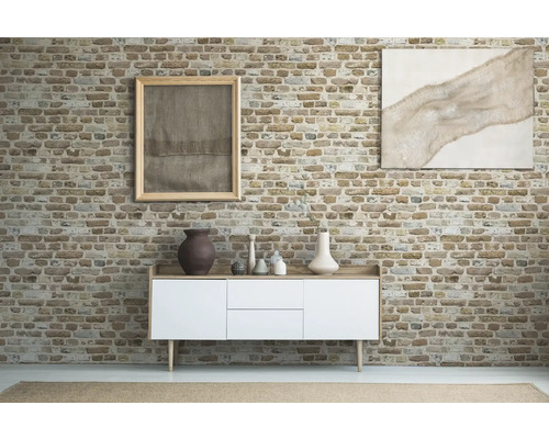 Woonkamer met dressoir, decoratie en schilderijen aan een bakstenen muur