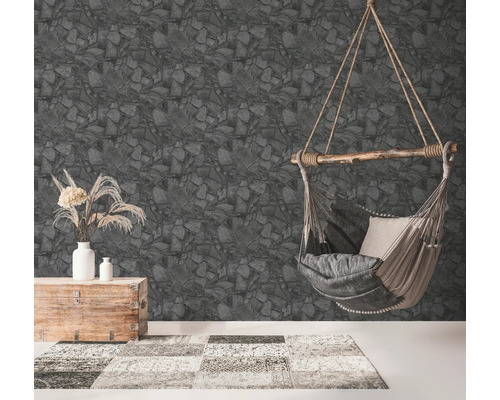 Woonkamer met behang met steenmotief, hangstoel, kist en vloerkleed