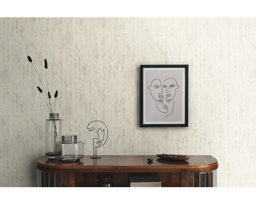 Woonkamer met patroonbehang, commode en decoratieve artikelen.