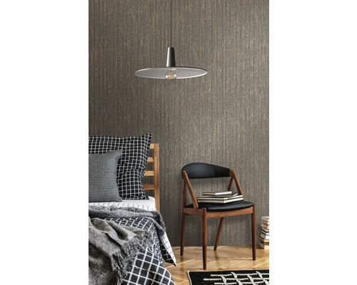 Slaapkamer met bed, stoel, lamp en behang met patroon