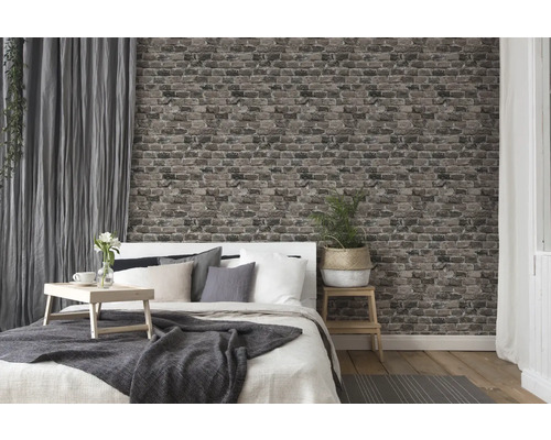 Slaapkamer met bed, nachtkastje, gordijnen en behang in baksteenmotief voor een gezellige sfeer