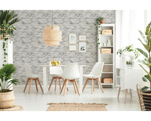Lichte eetkamer met eettafel, stoelen, rek en decoratieve elementen voor een muur met steenlook behang.