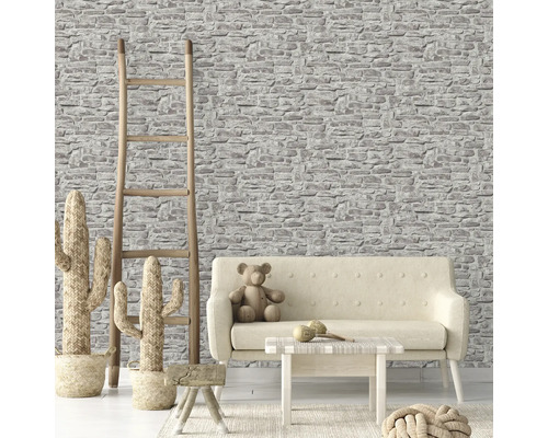 Woonkamer met stenen behang, bank en houten ladder