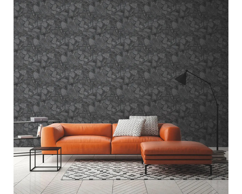 Woonkamer met grijs steenmotief behang, bank, vloerkleed en staande lamp