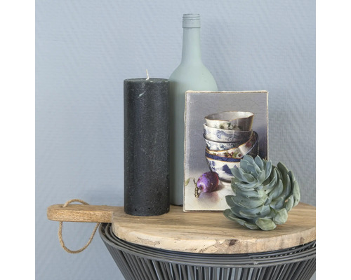 Decoratieve schikking met kaars, fles, foto en vetplant op een bijzettafel.