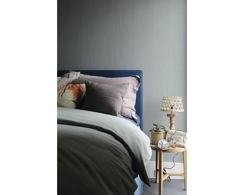 Slaapkamer met bed, nachtlamp en decoratie op een bijzettafel