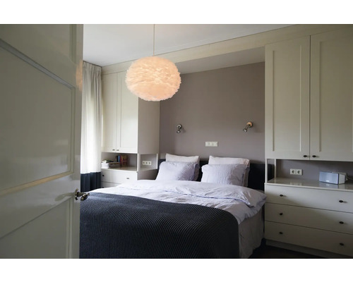 Slaapkamer met bed, nachtkastjes en veren lamp