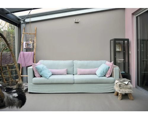 Lichte woonkamer met bank, decoratieve ladder en vitrine