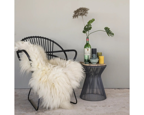 Decoratief interieur met stoel, vacht, bijzettafel, kaarsen en plantendecoratie