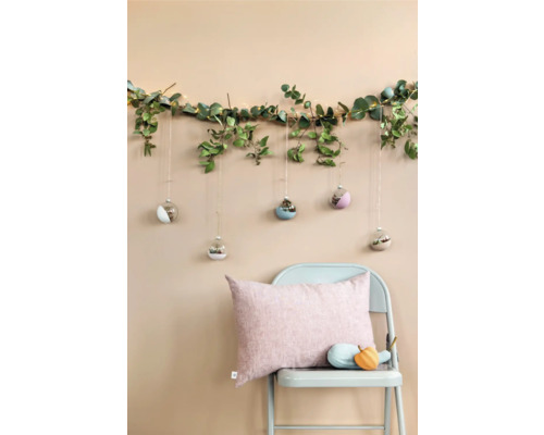 Decoratie met eucalyptus slinger, lichtslinger, glazen hangers en stoel met kussens