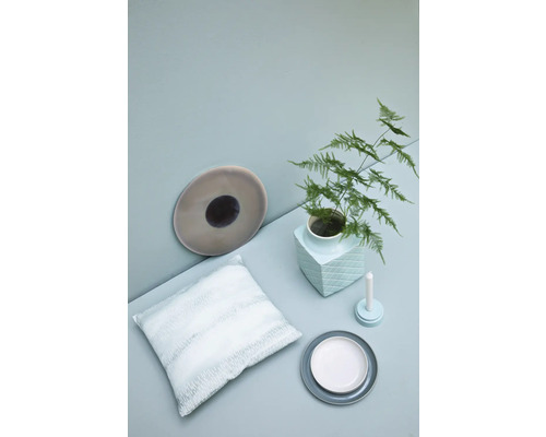 Decoratieve scène met kussen, borden, vaas, plant en kaars