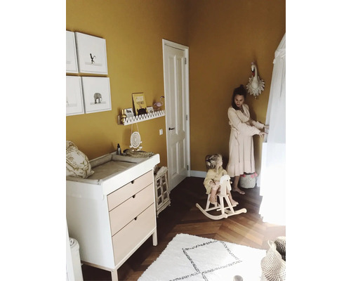Lichte kinderkamer met commode, houten hobbelpaard en wanddecoratie
