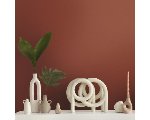 Decoratieve vazen en kandelaars op een wit oppervlak voor een gekleurde muur