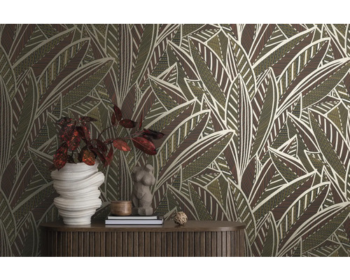 Kamer met een behang met bladerpatroon, een houten tafel en decoratieve objecten.