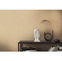 Decoratieve opstelling met beeld, vaas en boeken op een plank tegen een beige muur