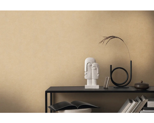 Decoratieve opstelling met beeld, vaas en boeken op een plank tegen een beige muur