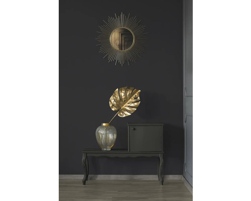 Decoratieve scène met spiegel, Monstera blad in vaas en klein kastje op een tafel