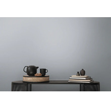 Decoratieve stillevenopstelling op een tafel met theepot, kop, schaal en boeken.