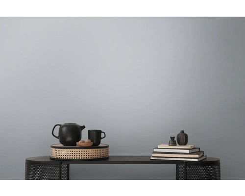 Decoratieve stillevenopstelling op een tafel met theepot, kop, schaal en boeken.