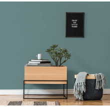 Decoratieve woonsfeer met dressoir, plant, mand en wanddecoratie