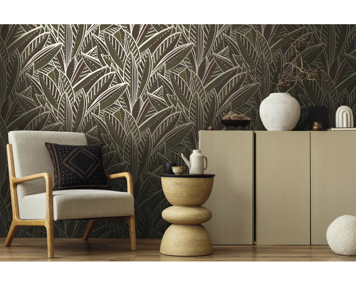 Woonkamer met fauteuil, dressoir en behang met bladerpatroon