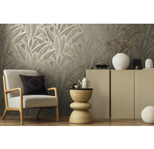 Woonkamer met behang met bladerpatroon, fauteuil en decoratie