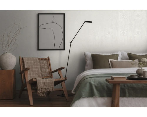 Woonkamer met fauteuil, staande lamp en bed
