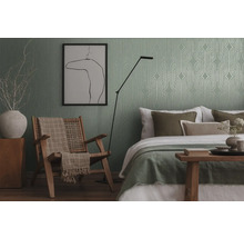 Slaapkamer met bed, stoel, vloerlamp en behang met patroon