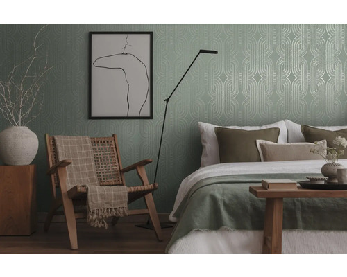 Slaapkamer met bed, stoel, vloerlamp en behang met patroon